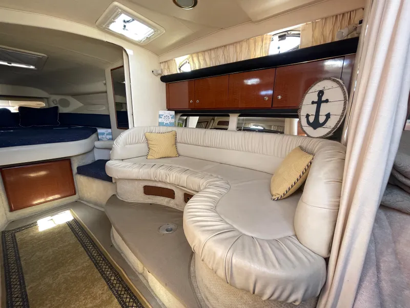 Slide: The Image of Interior of 2002 Sea Ray 340 Sundancer with beige leather seating and wooden cabinets. - 9