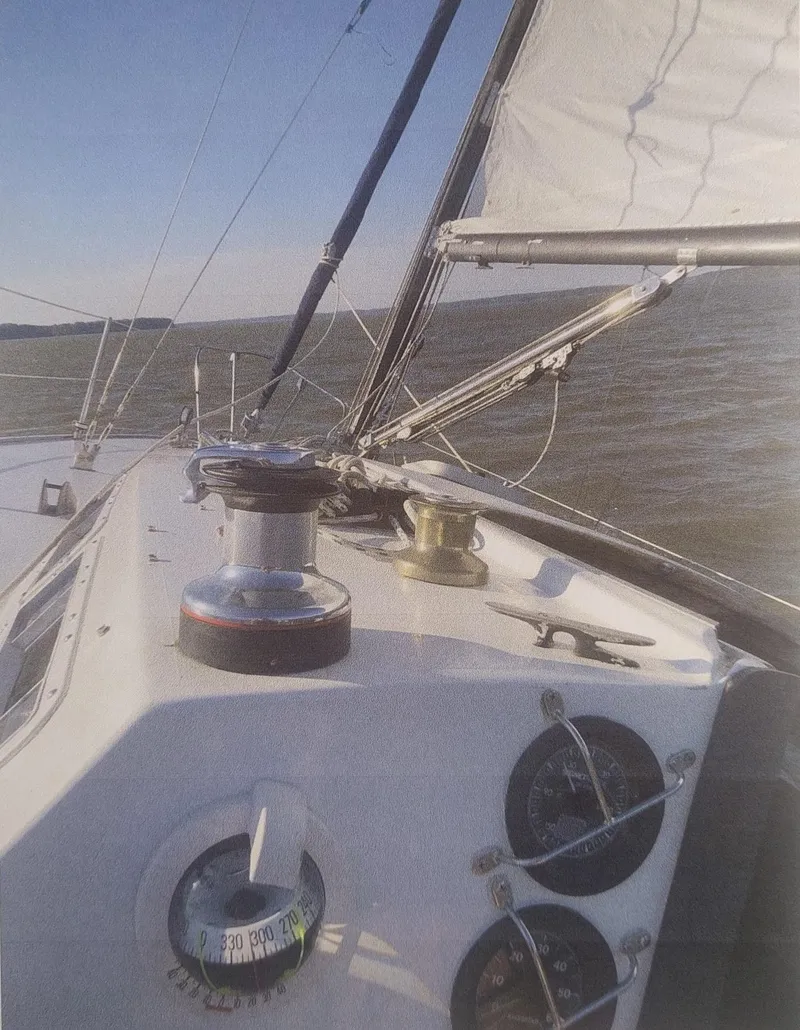 Slide: The Image of 1980 J Boats 30 sailboat deck with winch and compass, sailing on open water. - 4