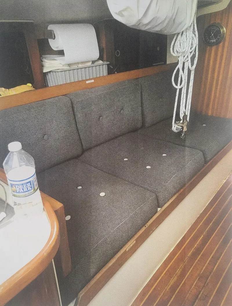 Slide: The Image of Interior of a 1980 J Boats 30 sailboat with cushioned seating and nautical decor. - 5