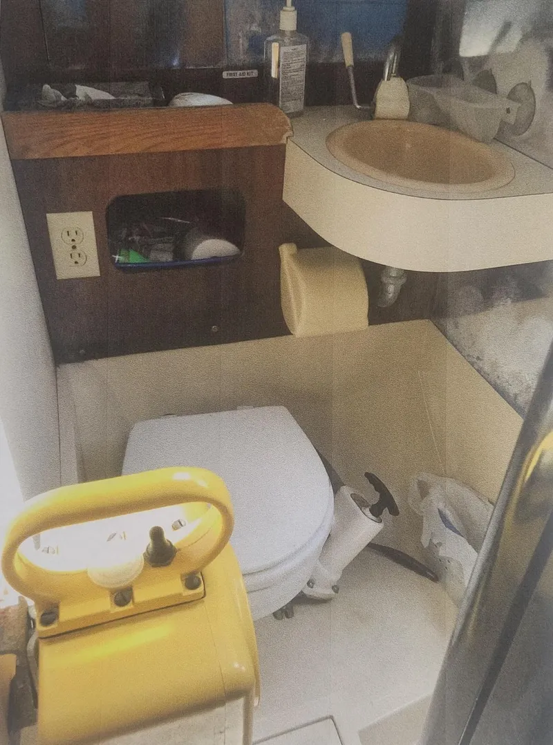Slide: The Image of 1980 J Boats 30 bathroom with sink, toilet, and storage shelves. - 6