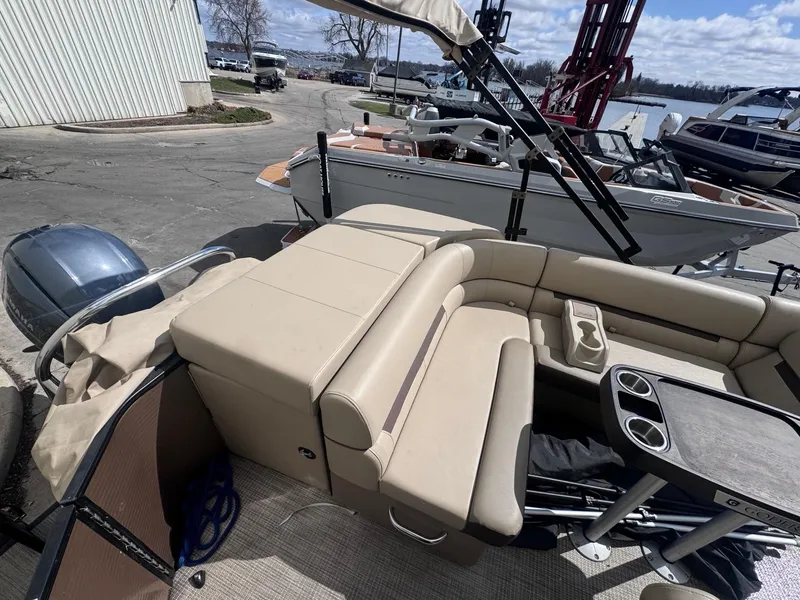 Slide: The Image of 2022 Sweetwater SW 2286 C pontoon boat with beige seating and cup holders, docked near water. - 12