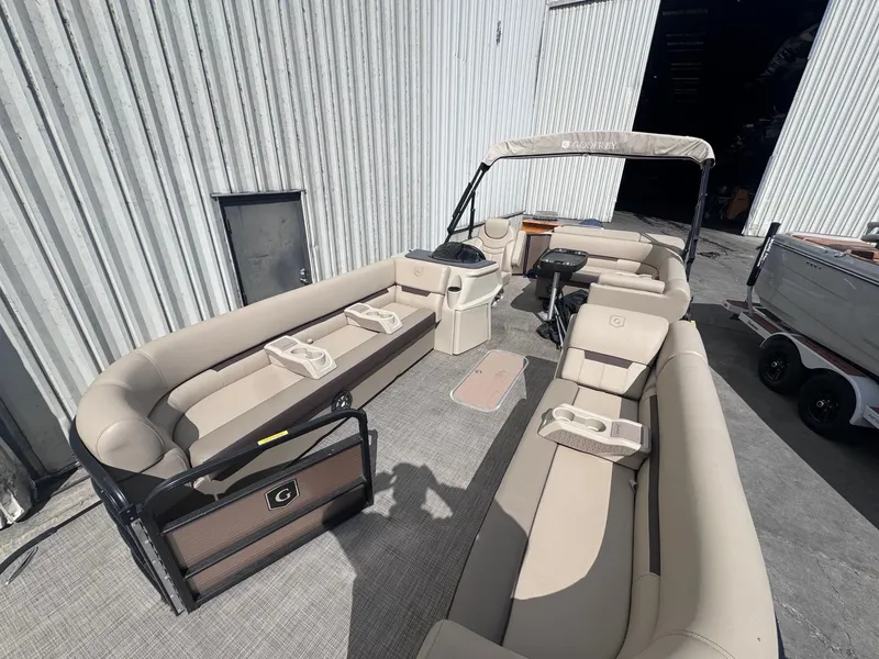 Slide: The Image of 2022 Sweetwater SW 2286 C pontoon boat with beige seating, docked near a warehouse. - 4