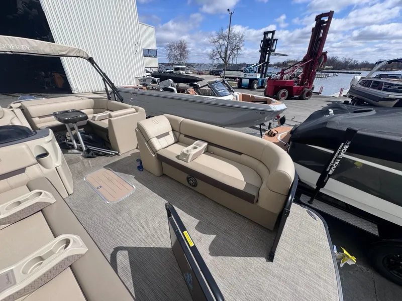 Slide: The Image of 2022 Sweetwater SW 2286 C pontoon boat with beige seating, docked near other boats. - 6