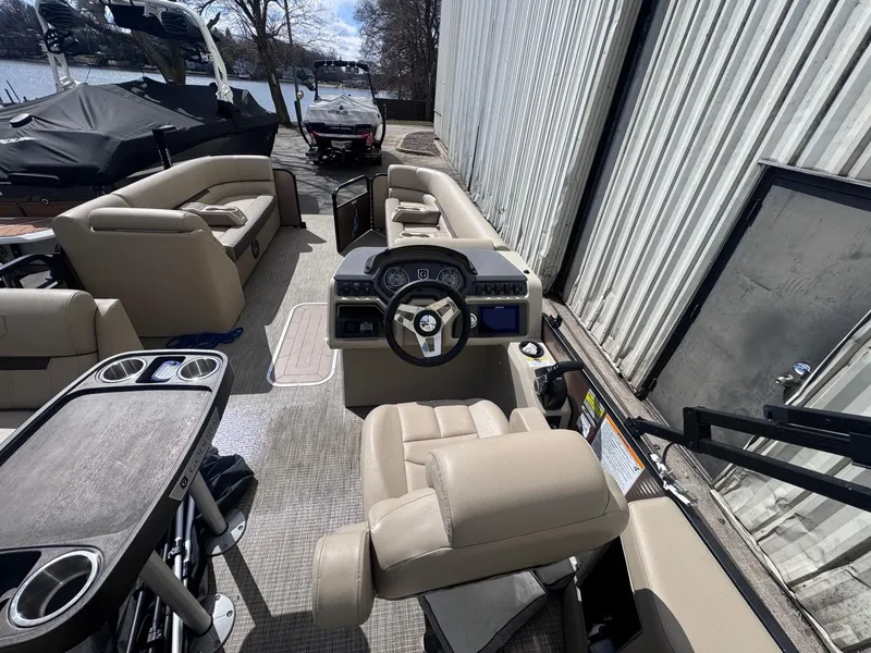 Slide: The Image of Interior of 2022 Sweetwater SW 2286 C pontoon boat with beige seating and steering console. - 9