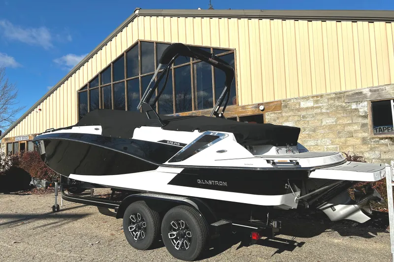 Slide: The Image of 2023 Glastron GTD 245 boat on a trailer outside a building. - 1