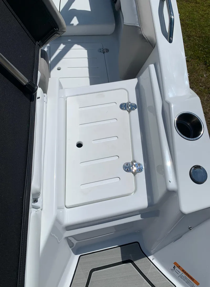 Slide: The Image of 2023 Glastron GTD 245 boat interior with storage compartment and cup holders. - 18
