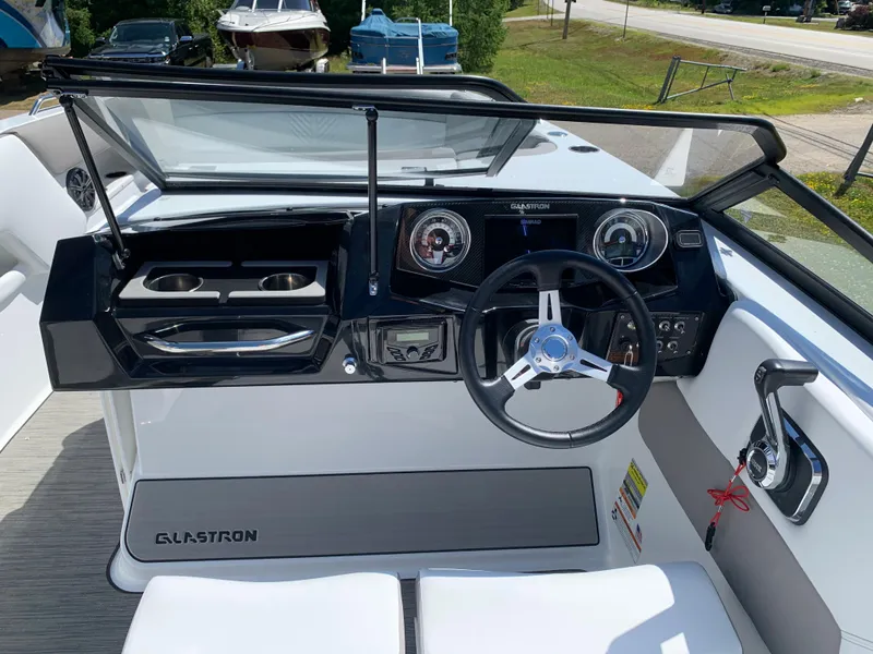 Slide: The Image of 2023 Glastron GTD 245 boat dashboard with steering wheel and controls. - 39