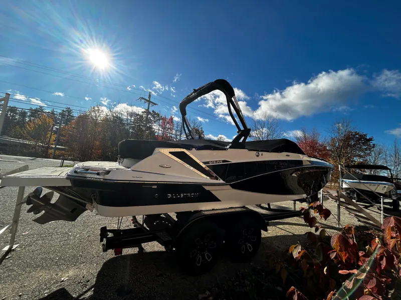 Slide: The Image of 2023 Glastron GTD 245 boat on a trailer under a bright sunlit sky. - 4