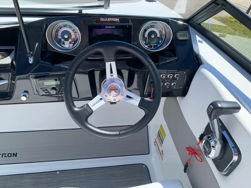 Slide: The Image of 2023 Glastron GTD 245 boat dashboard with steering wheel and control panel. - 41