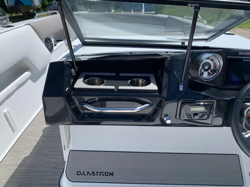 Slide: The Image of 2023 Glastron GTD 245 boat dashboard with cup holders and control panel. - 42