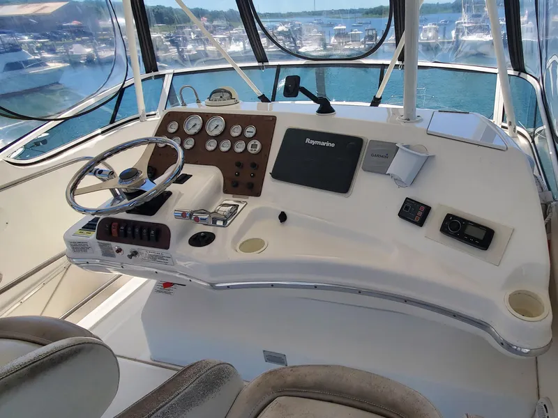 Slide: The Image of 2003 Silverton 38 Convertible helm with gauges, steering wheel, and navigation equipment. - 11