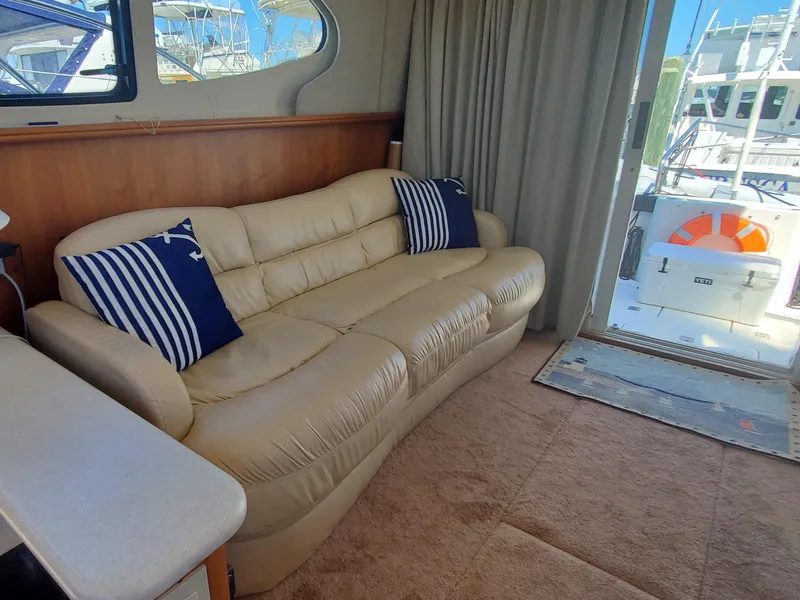 Slide: The Image of Interior of 2003 Silverton 38 Convertible yacht with beige sofa and striped pillows. - 18