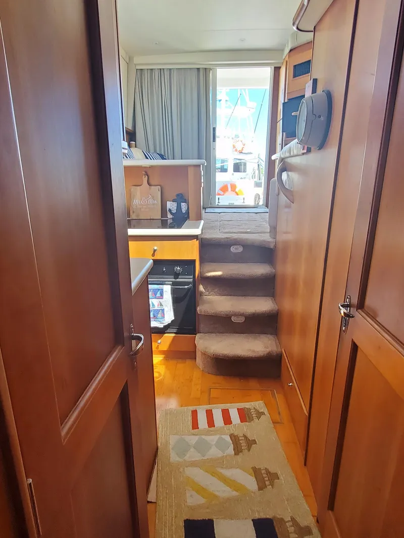 Slide: The Image of Interior view of 2003 Silverton 38 Convertible yacht with wooden cabinetry and carpeted stairs. - 21