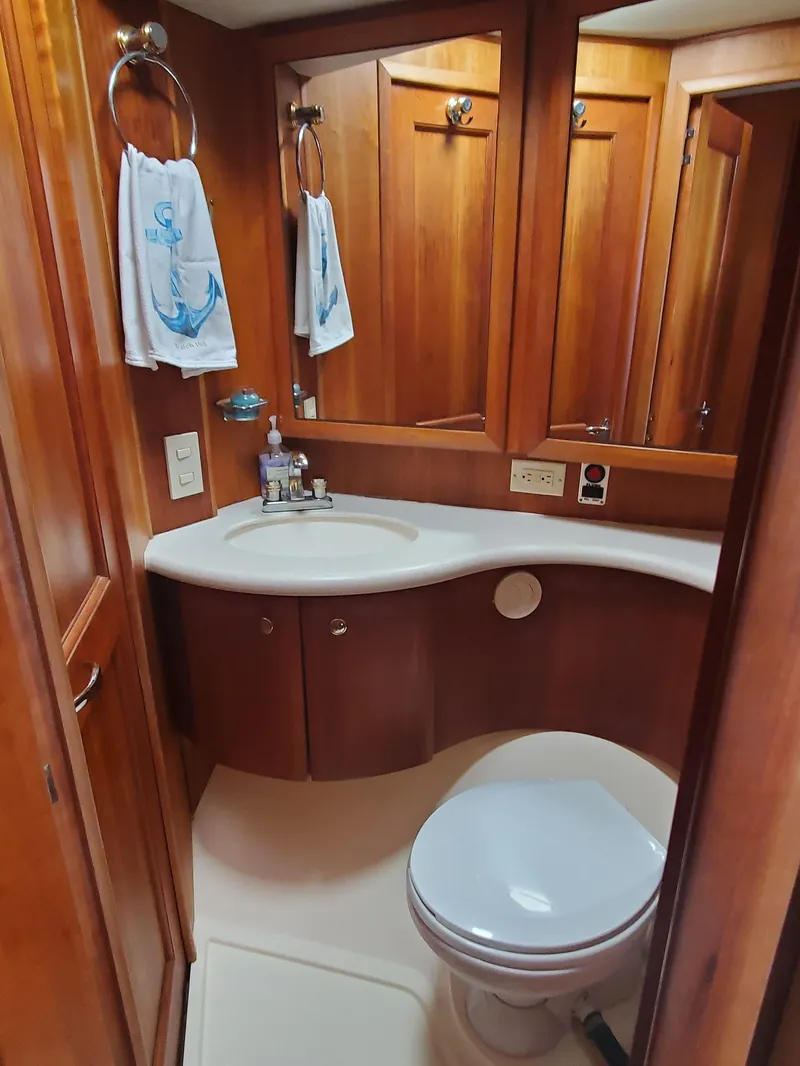 Slide: The Image of 2003 Silverton 38 Convertible yacht bathroom with wooden cabinetry and nautical-themed decor. - 23