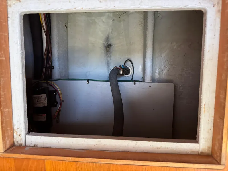 Slide: The Image of 2003 Silverton 38 Convertible interior compartment with wiring and hose connections. - 34