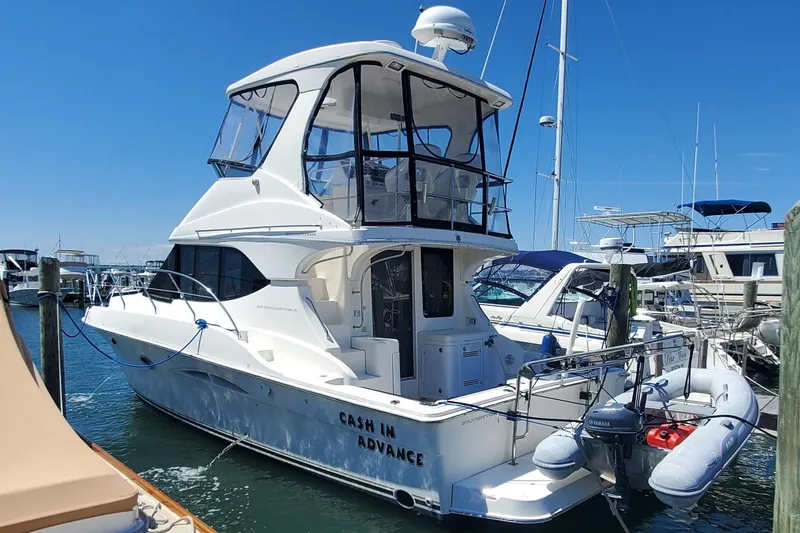 Slide: The Image of 2003 Silverton 38 Convertible yacht docked in a marina under clear blue skies. - 4