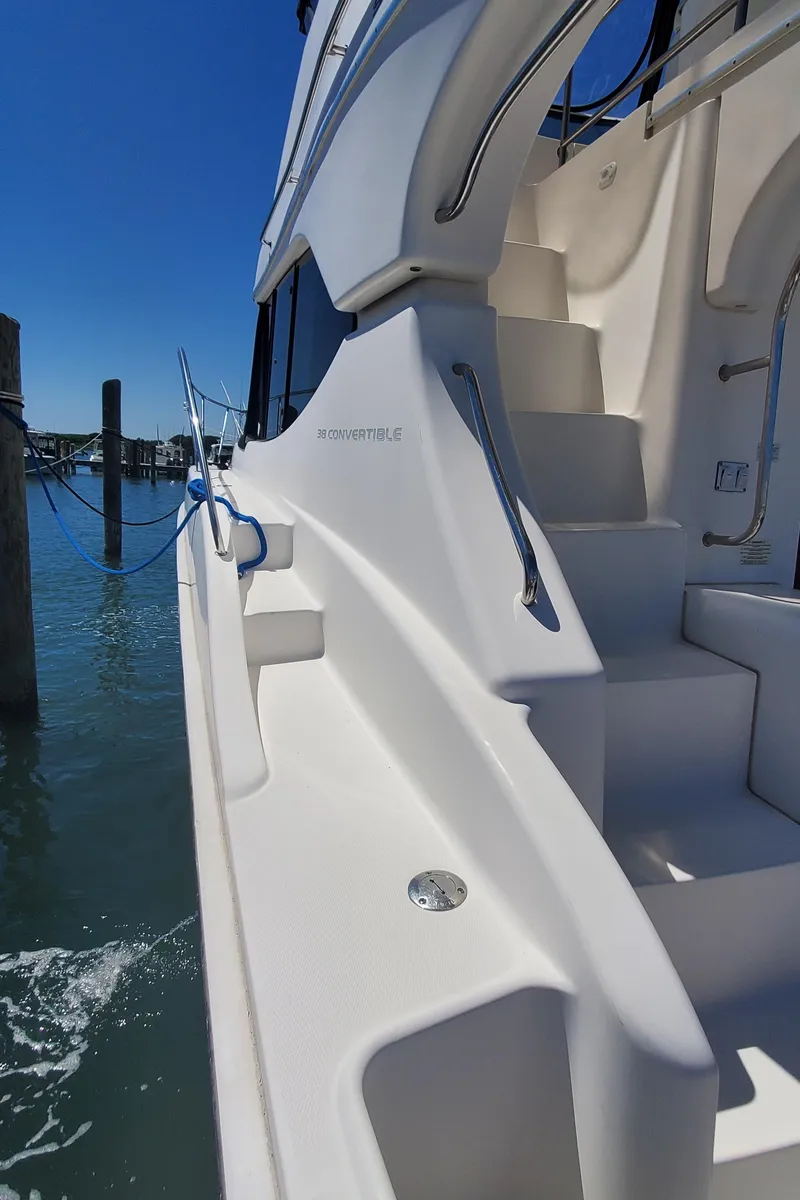 Slide: The Image of 2003 Silverton 38 Convertible yacht stairs with sleek design, docked by the water. - 6