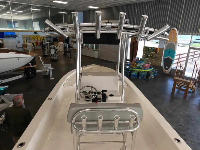 Slide: The Image of 2023 May-Craft 260 Bay boat interior in showroom, featuring helm and rod holders. - 4