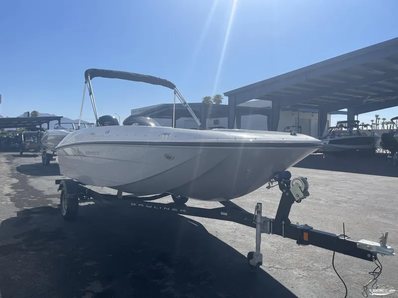 Slide: The Image of 2022 Bayliner E18 boat on trailer under sunny sky. - 2