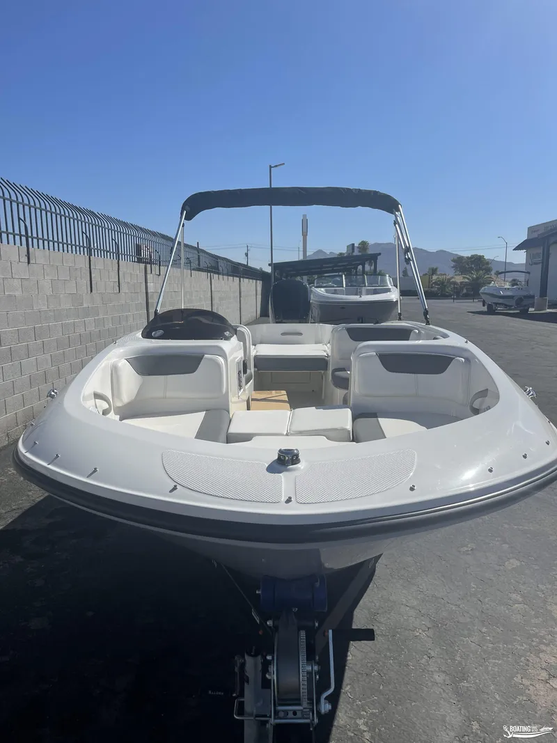 Slide: The Image of 2022 Bayliner E18 boat with canopy, parked outdoors on a sunny day. - 3