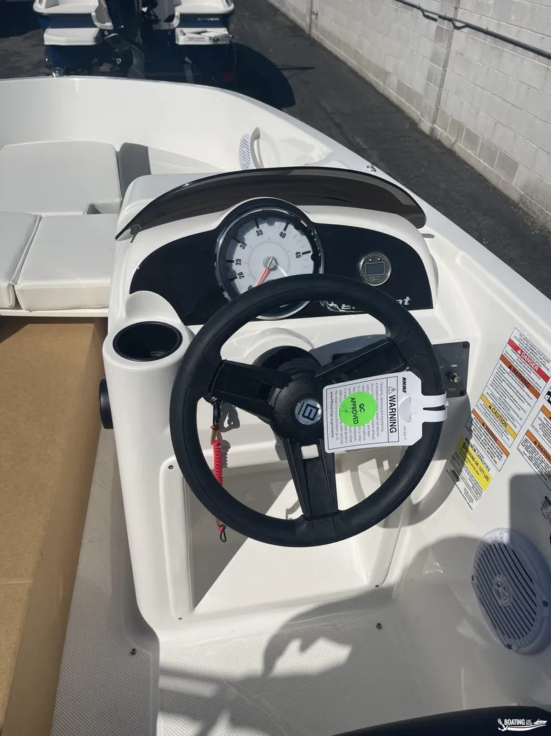 Slide: The Image of 2022 Bayliner E18 boat dashboard with steering wheel and gauges. - 4