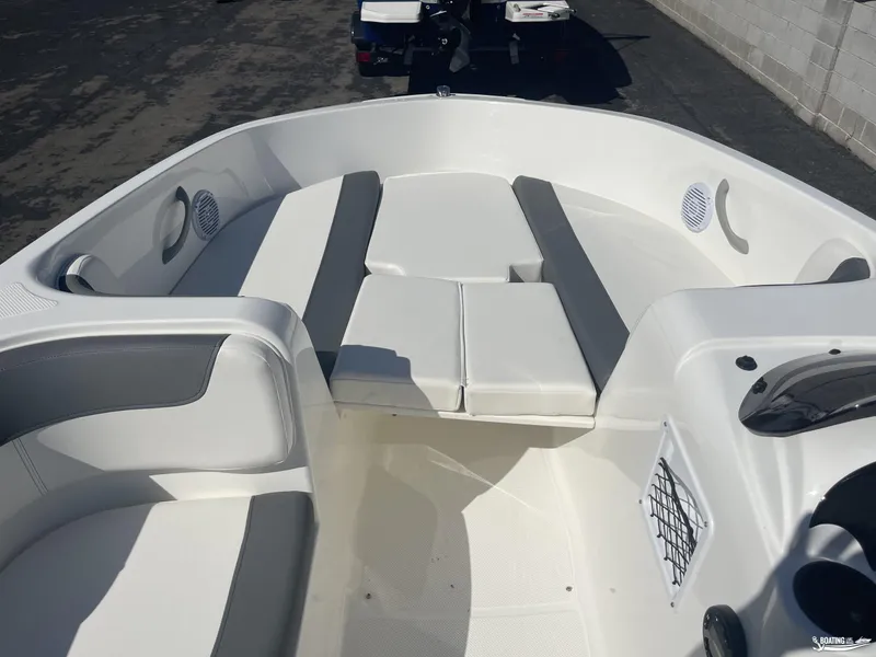 Slide: The Image of 2022 Bayliner E18 boat interior with white and gray seating. - 5