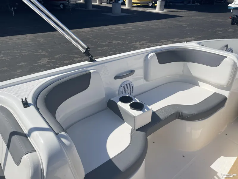 Slide: The Image of 2022 Bayliner E18 boat interior with gray seating and cup holders. - 6