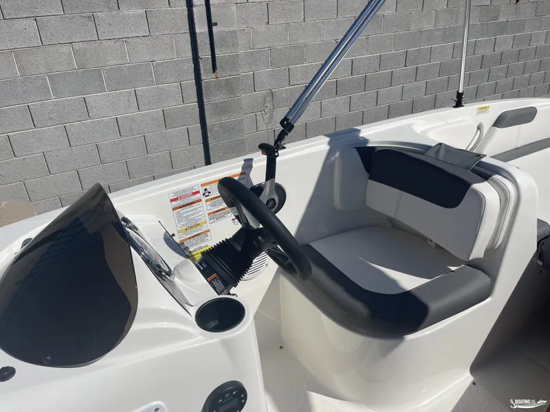 Slide: The Image of 2022 Bayliner E18 boat interior with steering wheel and seating. - 8