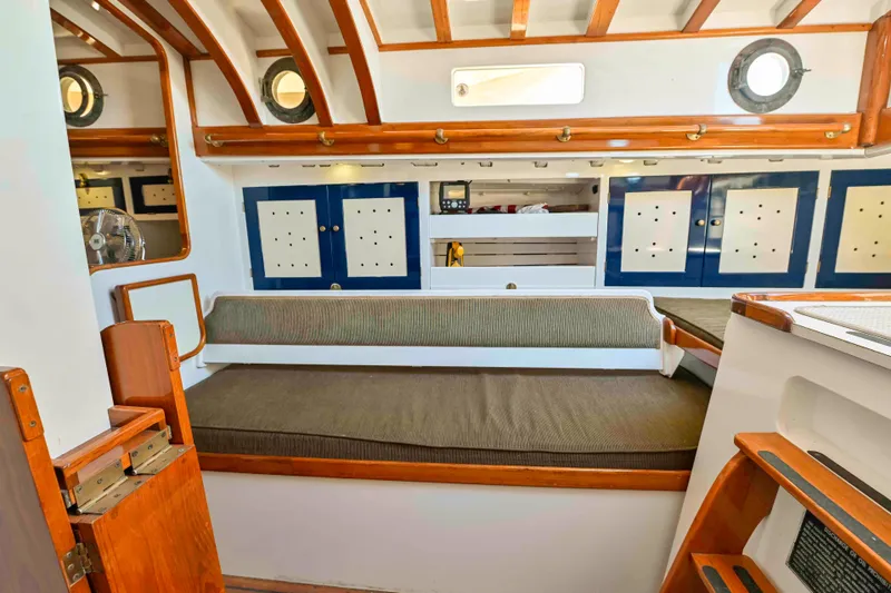 Slide: The Image of 1927 Schock Staysail Schooner interior with wooden accents and cozy seating area. - 16
