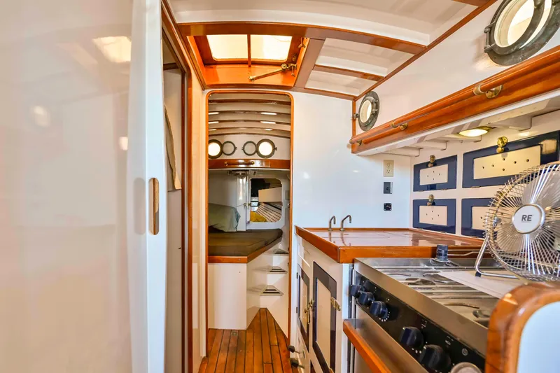 Slide: The Image of Interior of a 1927 Schock Staysail Schooner with wooden finishes and nautical decor. - 17