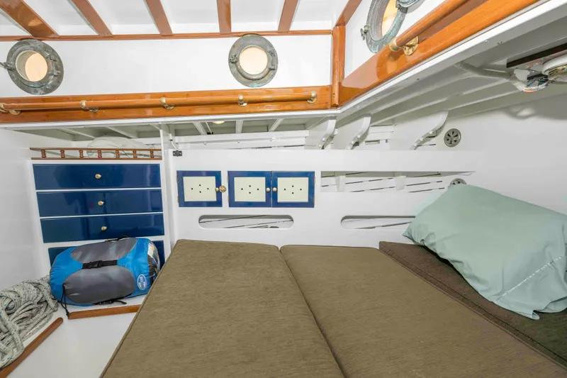 Slide: The Image of Cozy cabin interior of 1927 Schock Staysail Schooner with wooden accents and portholes. - 24