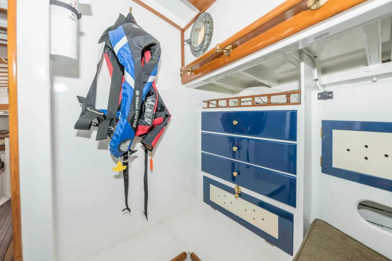 Slide: The Image of Interior of 1927 Schock Staysail Schooner with life jackets and blue storage drawers. - 25