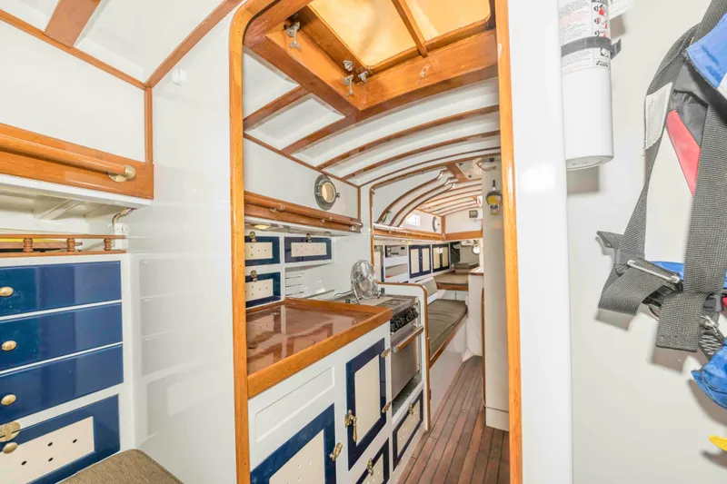Slide: The Image of Interior of a 1927 Schock Staysail Schooner with wooden cabinetry and nautical decor. - 28