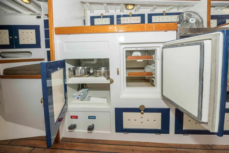 Slide: The Image of Interior of 1927 Schock Staysail Schooner with open cabinets and wooden flooring. - 34