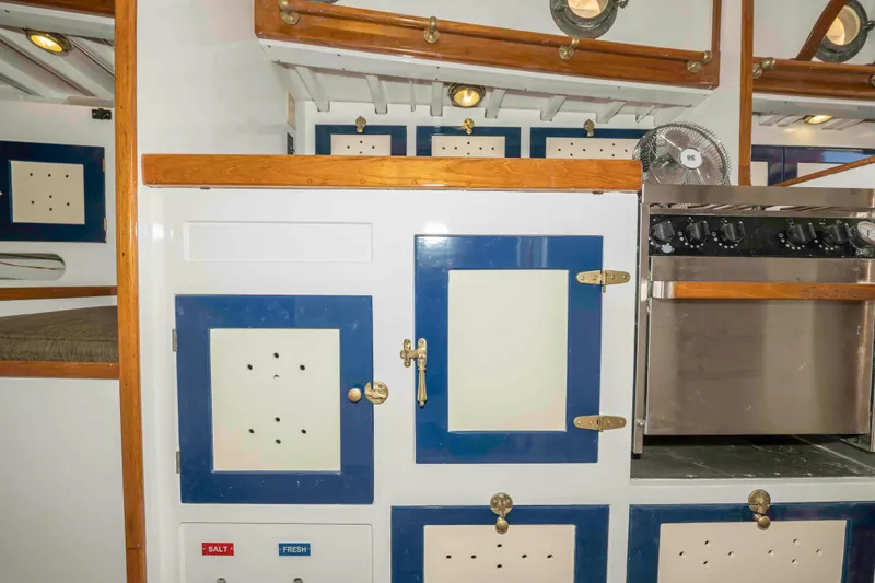 Slide: The Image of Interior of 1927 Schock Staysail Schooner with vintage cabinetry and stove. - 35