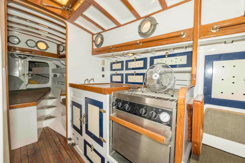 Slide: The Image of Interior of a 1927 Schock Staysail Schooner with wooden cabinetry and nautical decor. - 36