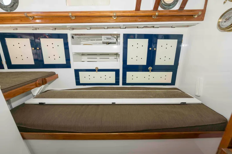 Slide: The Image of 1927 Schock Staysail Schooner interior with wooden cabinets and cushioned seating. - 40