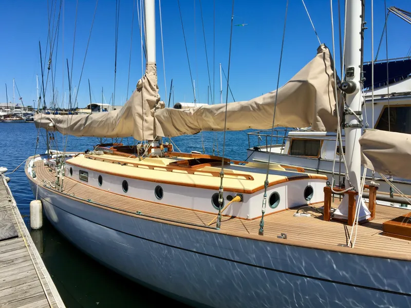Slide: The Image of 1927 Schock Staysail Schooner docked at marina under clear blue sky. - 7