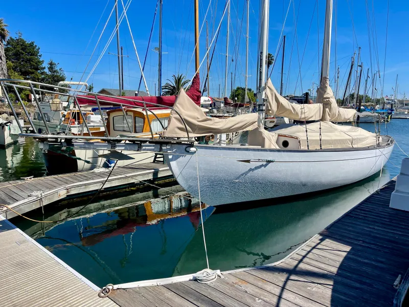 Slide: The Image of 1927 Schock Staysail Schooner docked at a marina, reflecting on calm water. - 9