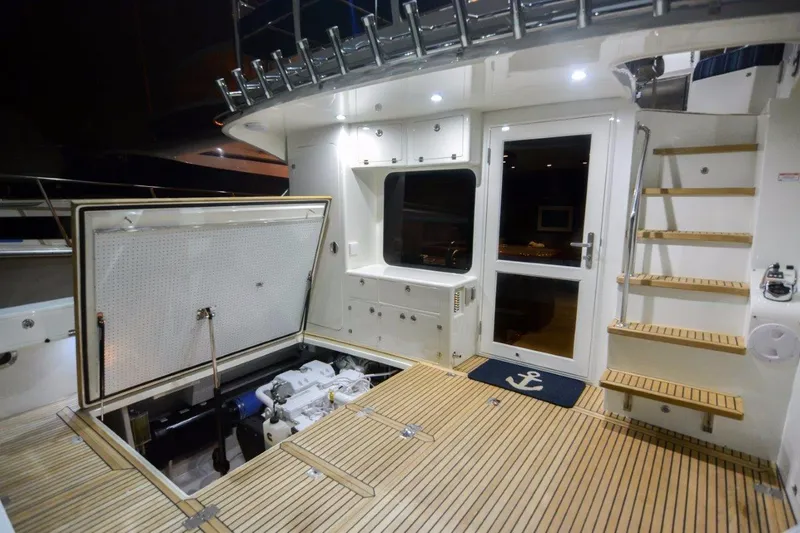 Slide: The Image of 2026 Mikelson 50 Generation II Sportfisher yacht interior with open hatch and wooden deck. - 11