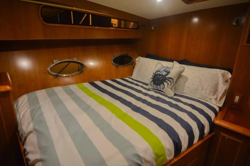Slide: The Image of Cozy cabin bedroom in 2026 Mikelson 50 Generation II Sportfisher yacht with striped bedding. - 7