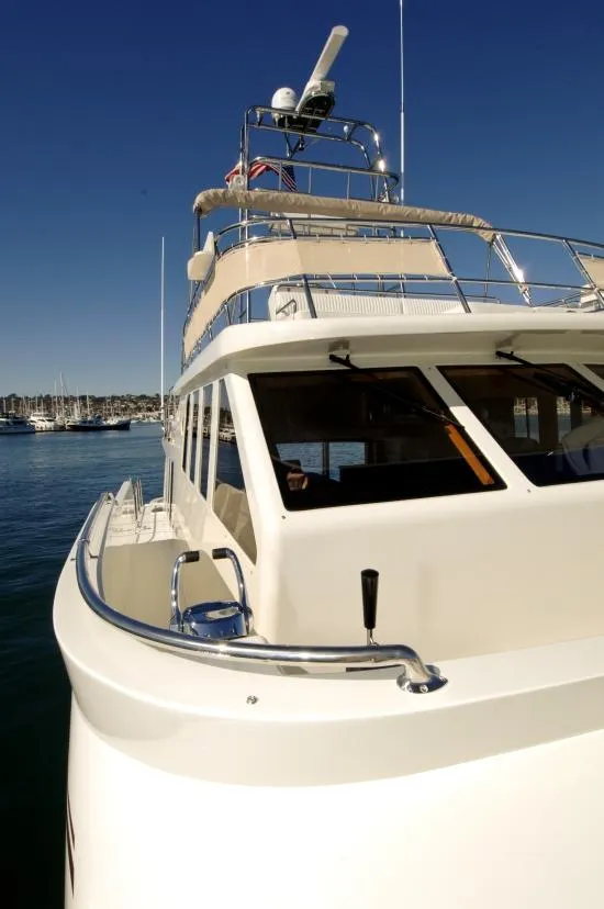 Slide: The Image of 2026 Mikelson Nomad Long Range Cruising Sportfish yacht on calm water under clear blue sky. - 11