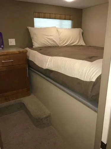 Slide: The Image of Compact bedroom in 2015 Bravada Why Knot Week 10 RV with elevated bed and storage. - 10