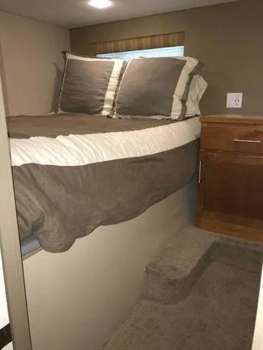 Slide: The Image of Compact bedroom in 2015 Bravada Why Knot Week 10 RV with elevated bed and storage. - 19