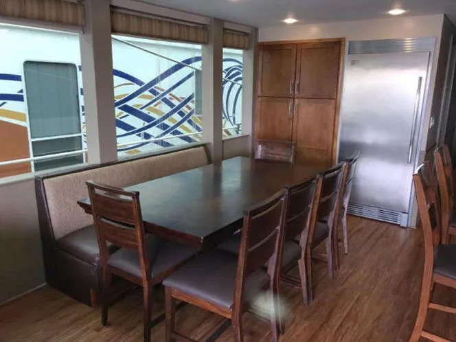 Slide: The Image of Dining area in 2015 Bravada Why Knot Week 10 houseboat with wooden table and chairs. - 31