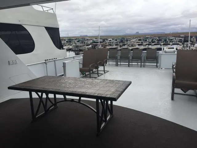 Slide: The Image of Bravada Why Knot Week 10 houseboat deck with table and chairs, marina view, 2015. - 4
