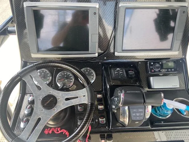 Slide: The Image of Dashboard of a 2014 ShearWater 26 Carolina boat with dual screens and steering wheel. - 17