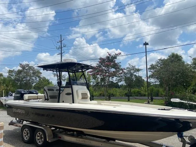 Slide: The Image of 2014 ShearWater 26 Carolina boat on a trailer under a partly cloudy sky. - 4