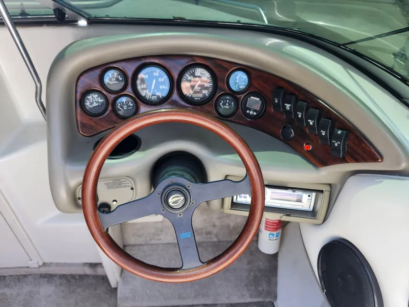 Slide: The Image of 1998 Crownline 202 CC boat dashboard with wood trim and gauges. - 11