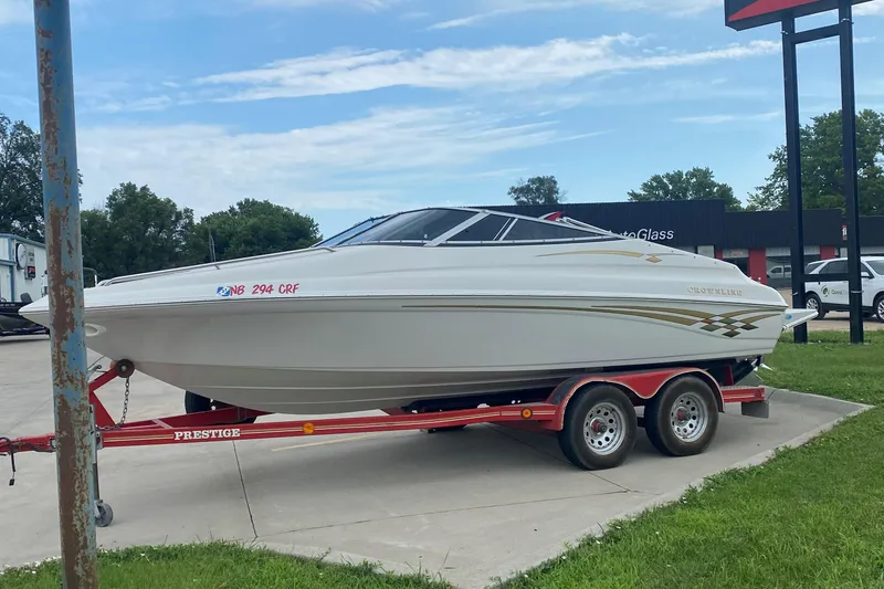 Slide: The Image of 1998 Crownline 202 CC boat on a red trailer in a parking lot. - 6